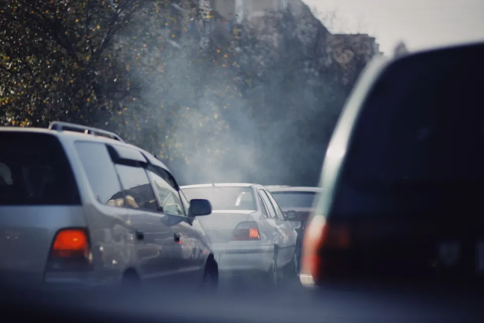 Exhaust hanging in the air over a line of cars in traffic